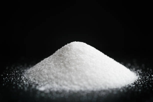 heap of extra small salt on black background, shallow focus